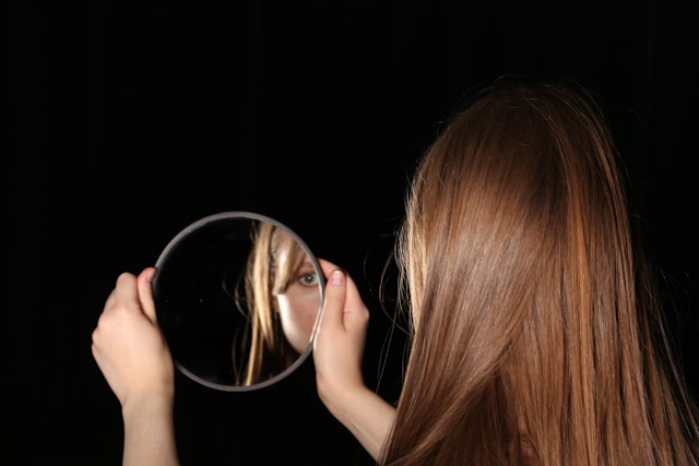Częściowe odbicie twarzy kobiety widoczne w lustrze
