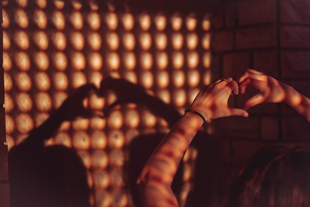 Dłónie kobiety ułożone tak, aby rzucały cień serca