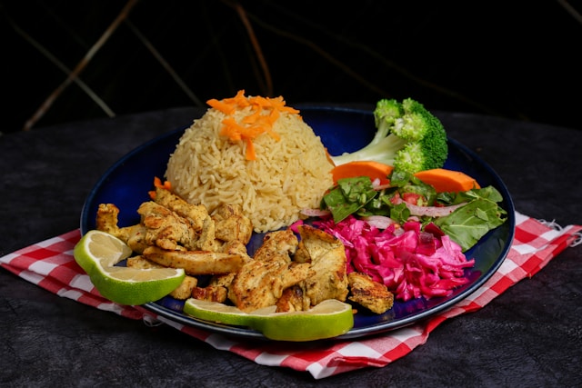 Talerz owocami, warzywami i kulą kaszy stojący na serwtce w czerwoną kratkę